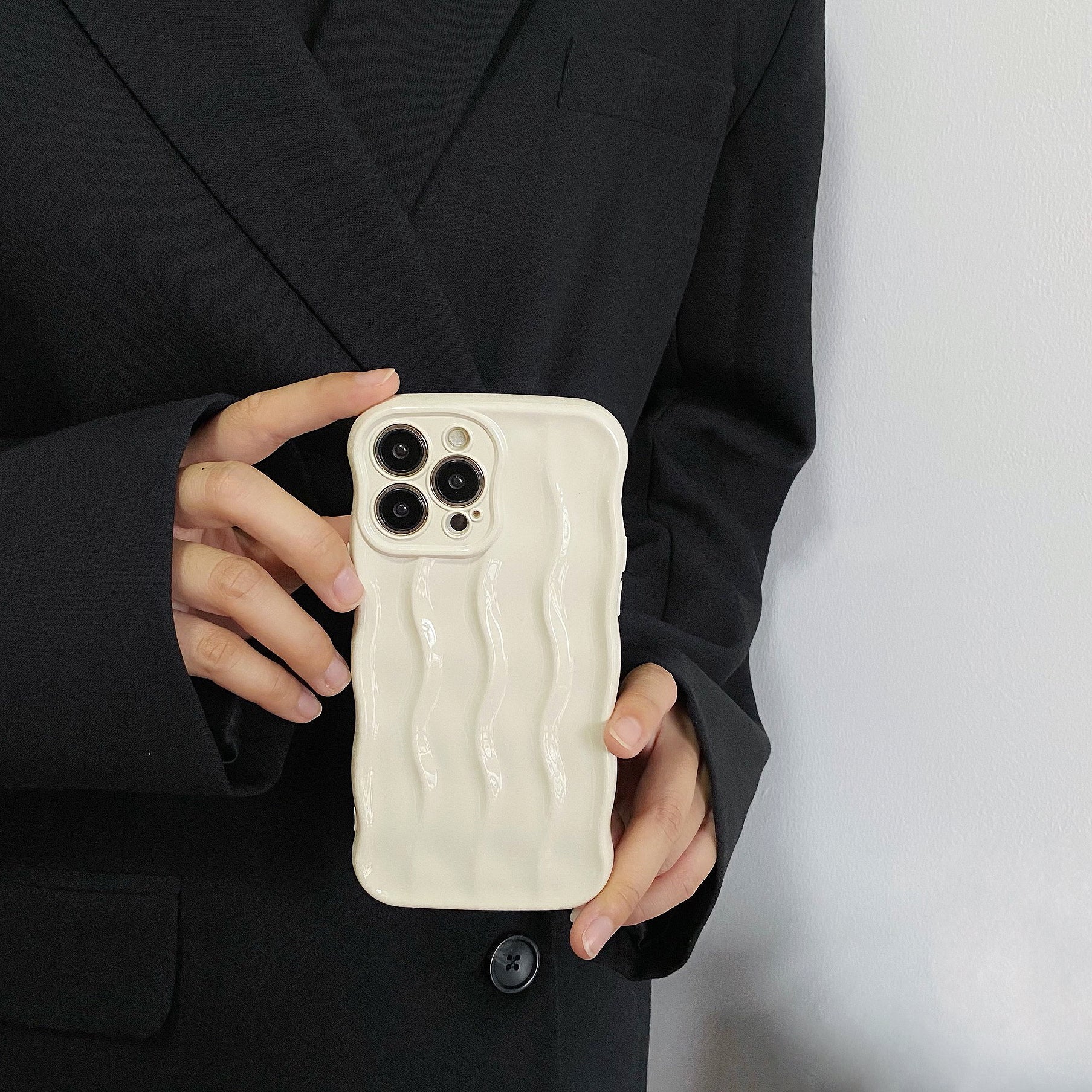 Hand holding the white 3D wave silicone phone case.