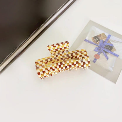 Flat lay of Rectangle Hair Claw in yellow plaid, easy for workdays and special occasions.
