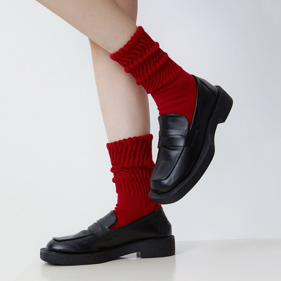 Model wearing a pair of Red cotton slouch socks with a ruched design.