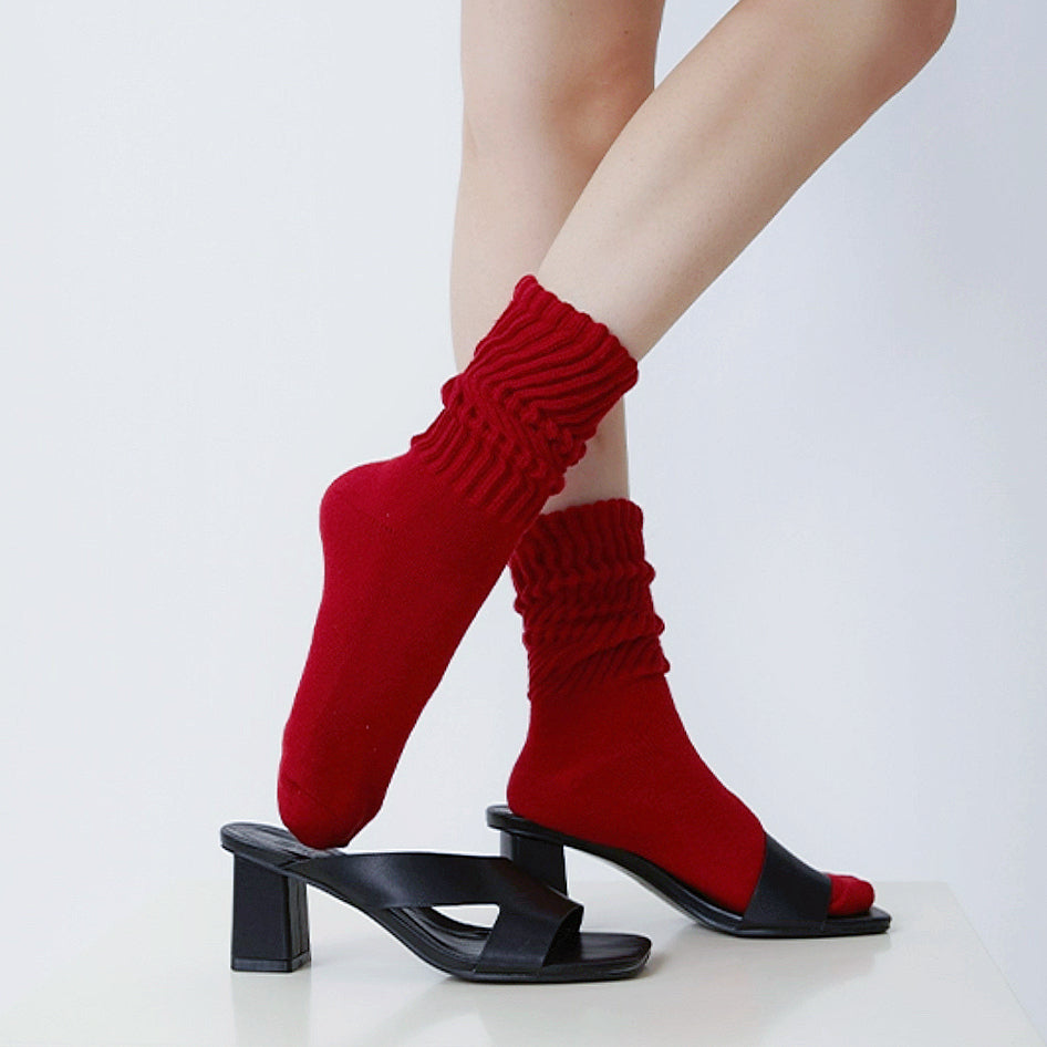 Model wearing a pair of red slouch socks, easy for travel days and daily comfort.