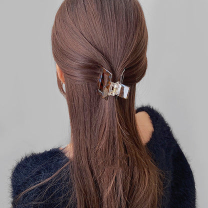 Model wearing Retro Hair Claw in cube shape, easy for workdays and special occasions.