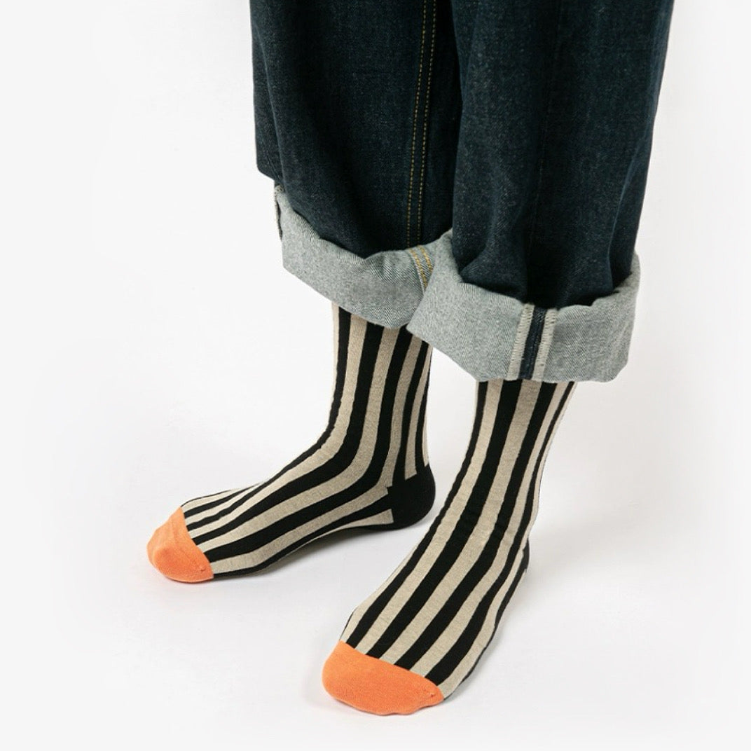 Model wearing a pair of orange striped cotton socks, easy for travel days and daily comfort.