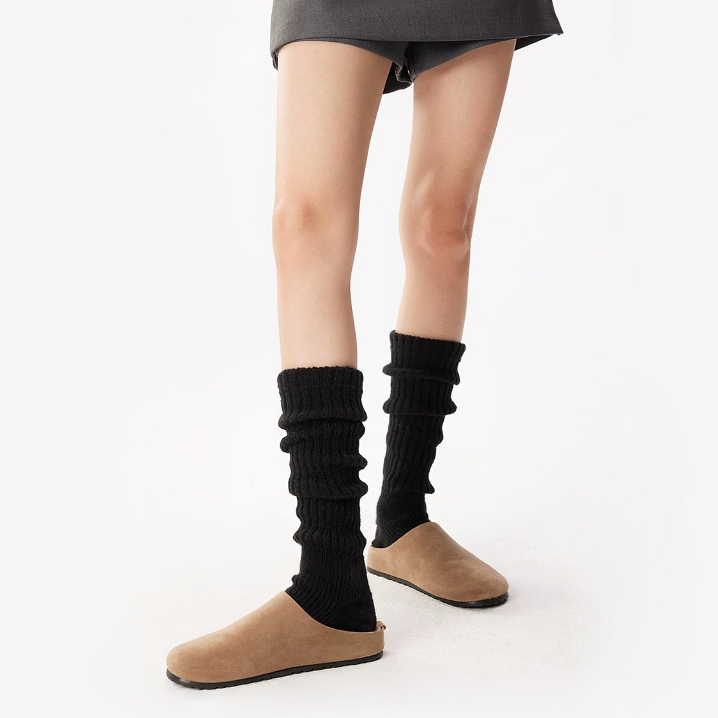 Model wearing a pair of black Ribbed Knit Leg Warmers, great for casual wear and light workouts.
