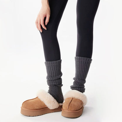Model wearing a pair of dark gray Ribbed Knit Leg Warmers, easy for travel days and daily comfort.
