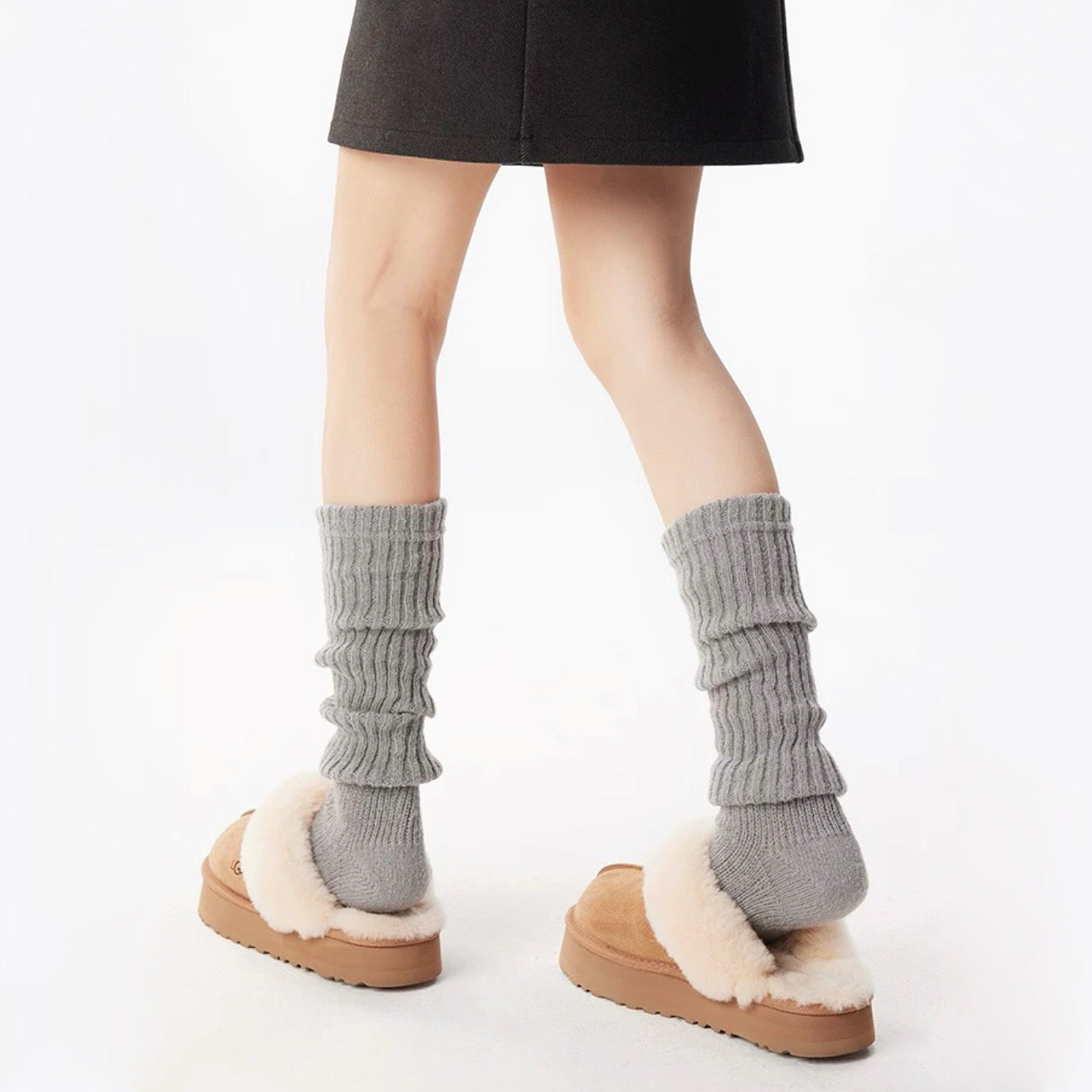 Model wearing a pair of light gray  Ribbed Knit Leg Warmers, ideal for everyday outfits and sneakers.