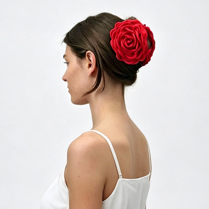 Side profile of a model wearing a bold red fabric rose hair claw clip.