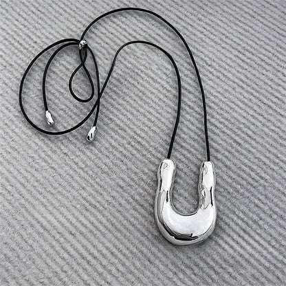 Flat lay of Silver Crescent Pendant Necklace, great for everyday outfits.
