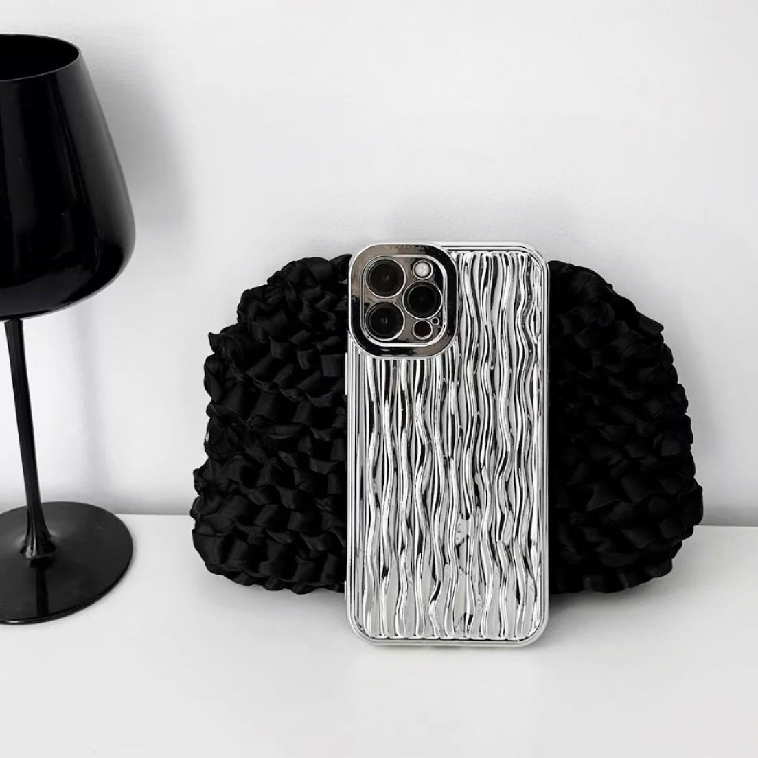 Silver water ripple design silicone case with a protective metallic camera bezel.
