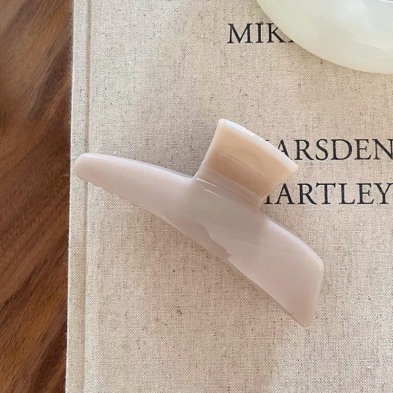 Close-up of Sleek Curved Hair Claw  in beige, ideal for quick updos and ponytails.