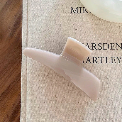 Close-up of Sleek Curved Hair Claw  in beige, ideal for quick updos and ponytails.