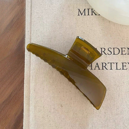Angled view of Sleek Curved Hair Claw in olive green, ideal for quick updos and ponytails.