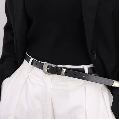 Minimalist leather belt styled with white formal high-waisted trousers.