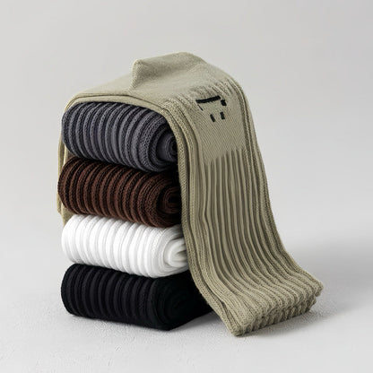 Stack of five pairs of cotton-polyester slouch socks in olive green, gray, brown, white, and black.
