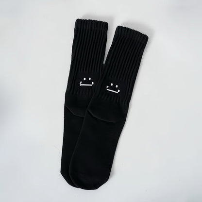 Front view of Smile Slouch Socks in black, easy to pack for travel and errands.