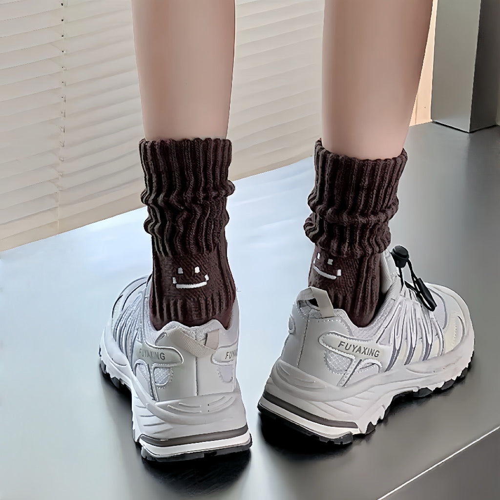 Model wearing a pair of Smile Slouch Socks in brown, easy to pack for travel and errands.