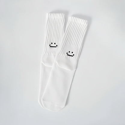 Folded view of Smile Slouch Socks in white, ideal for workouts and commuting.