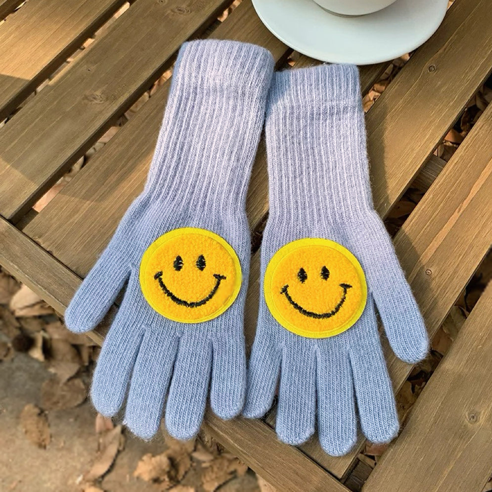 Baby blue smiling round face gloves with soft knit texture; cute cozy gloves for winter outings.
