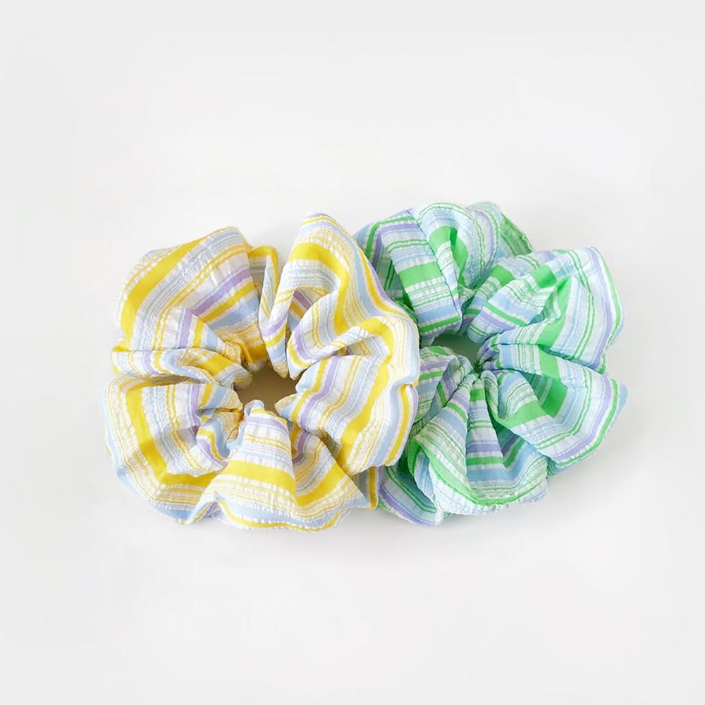 Angled view of two Stripe Scrunchies shown together, yellow and green.