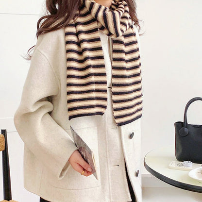 Model wearing a striped knit scarf in black and khaki, easy for weekend styling and gifting.