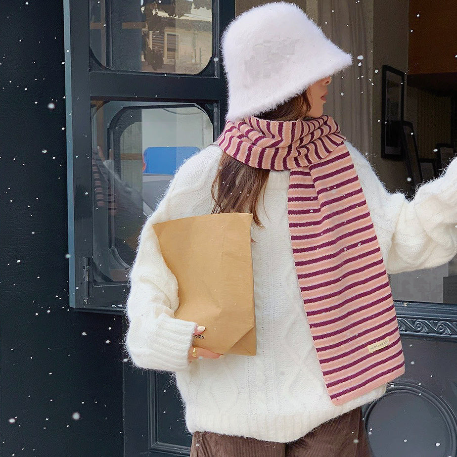 Model wearing a striped knit scarf in pink, easy for weekend styling and gifting.