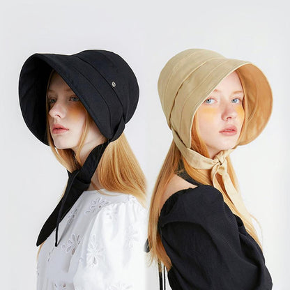 Side-by-side view of models wearing the Sun Shield Ribbon Bucket Hat in black and cream yellow.