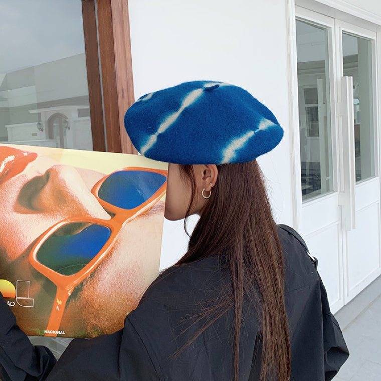 Side view of the blue tie-dye beret highlighting the unique pattern distribution.