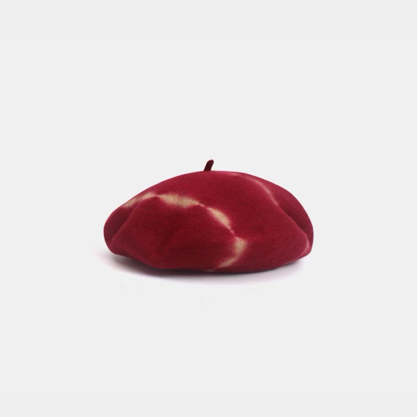 Red and white tie-dye wool beret displayed on a white background.
