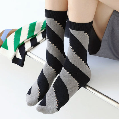 Model wearing a pair of Twill Cutout Socks in black and gray stripe, easy to pack for travel and errands.