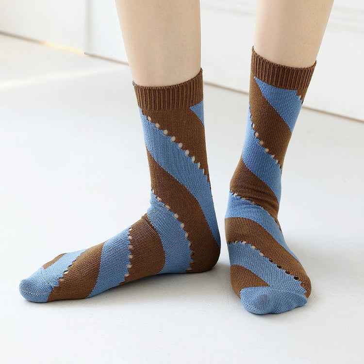 Model wearing a pair of Twill Cutout Socks in brown and blue stripe, easy to pack for travel and errands.