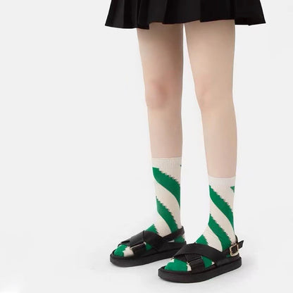 Model wearing a pair of Twill Cutout Socks in white and green stripe, great for daily wear and lounging.