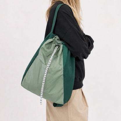 Model carrying the green convertible 2-way nylon backpack as a shoulder tote bag.