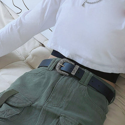 Black PU leather belt with an ornate vintage silver buckle, worn with green cargo pants.