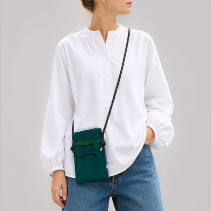 Model wearing the Dark Teal pleated knit mini bag over a plain white button-down shirt.
