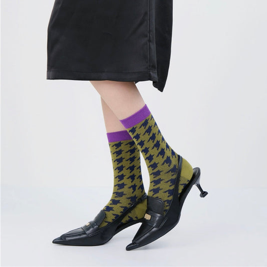Model wearing a pair of lilac socks cotton socks, with olive green and navy houndstooth pattern.