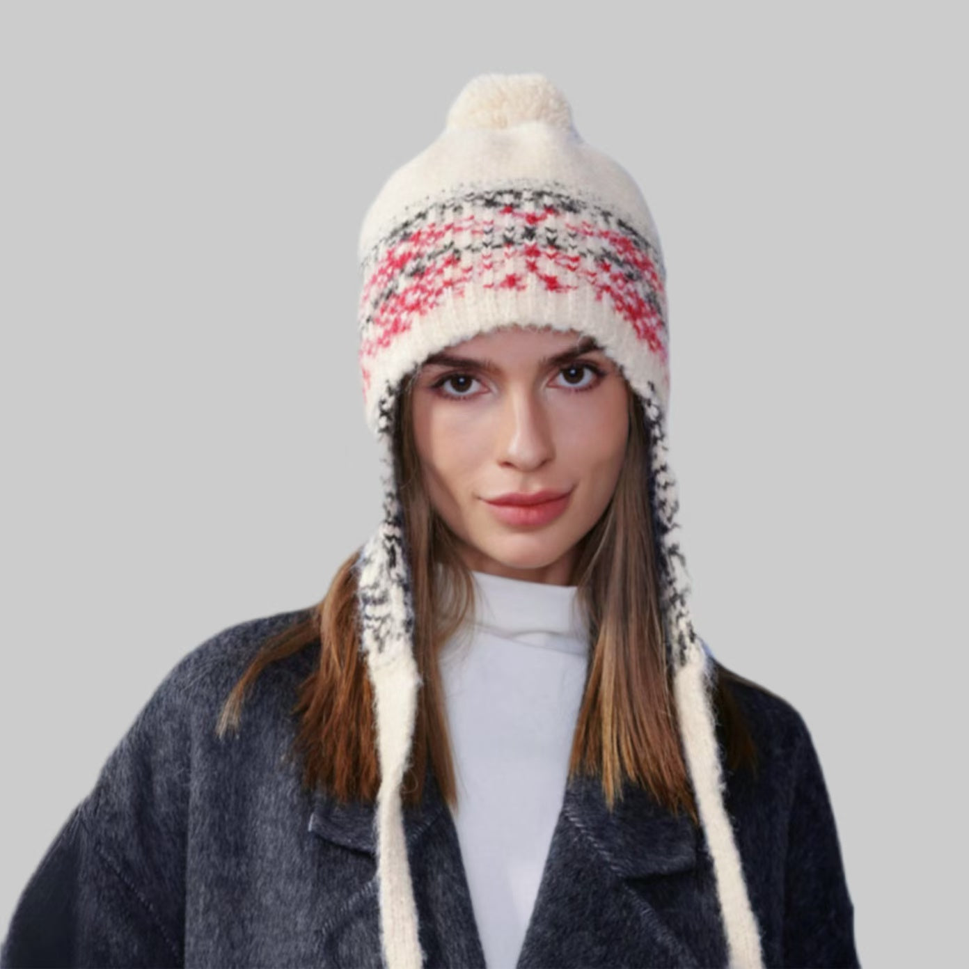 Model wearing beige Winter Isle Ear Flap Hat, displaying traditional Fair Isle patterns in a thick warm knit.