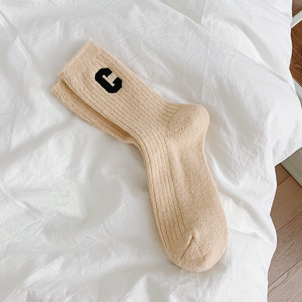 Flat lay of Wool C Socks in beige, great for daily wear and lounging.
