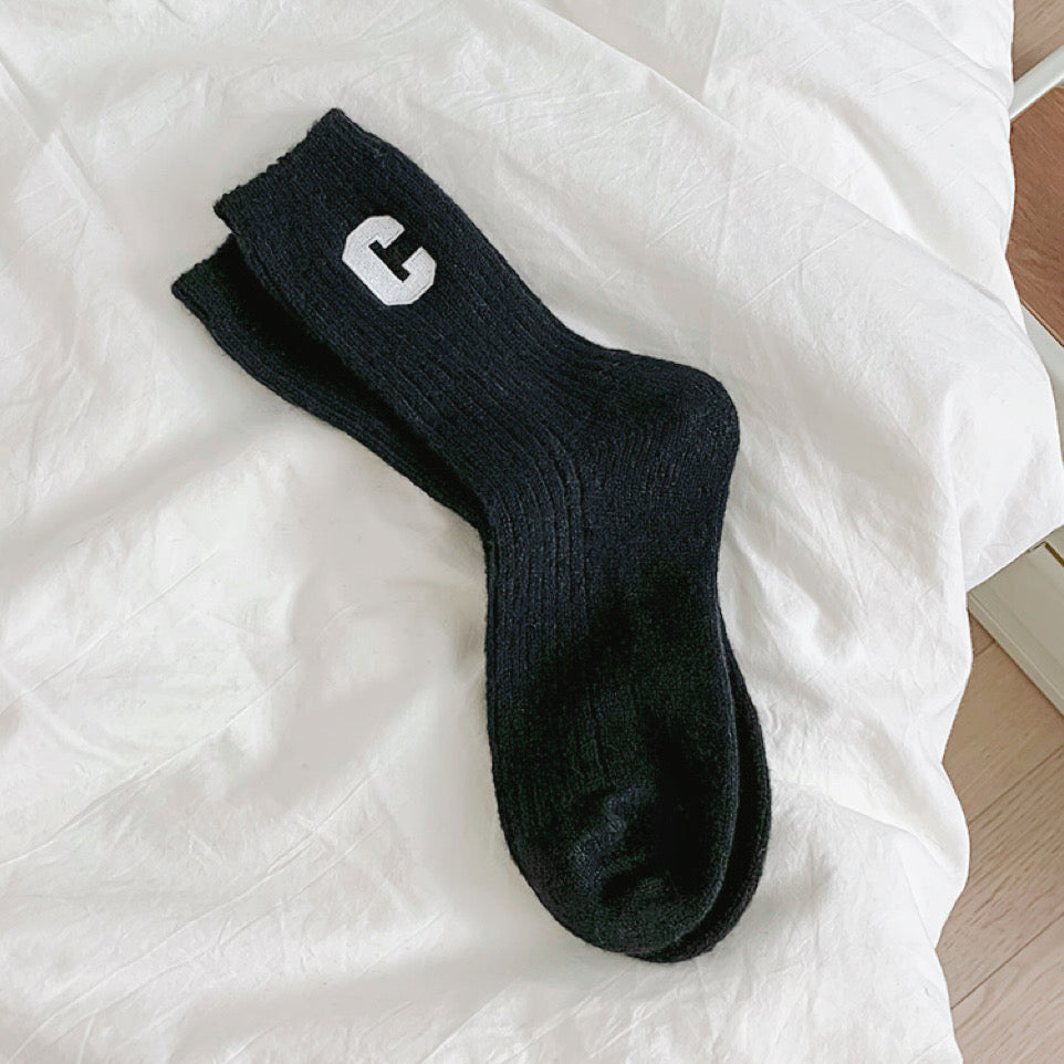 Angled view of Wool C Socks in black, great for daily wear and lounging.