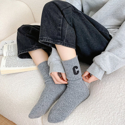 Model wearing a pair of gray wool socks, easy for travel days and daily comfort.